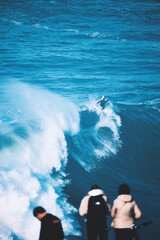 Naklejka premium Surfers Conquer Massive Waves in Nazaré
