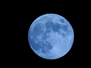 Moon in the night sky against a dark black background