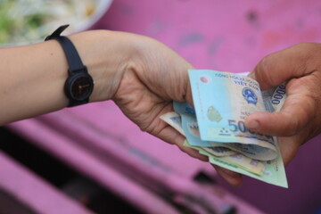 Vietnamese money being exchanged in a market. 