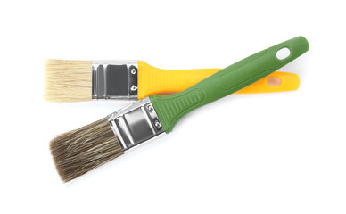 Two paint brushes with colorful handles isolated on white, top view