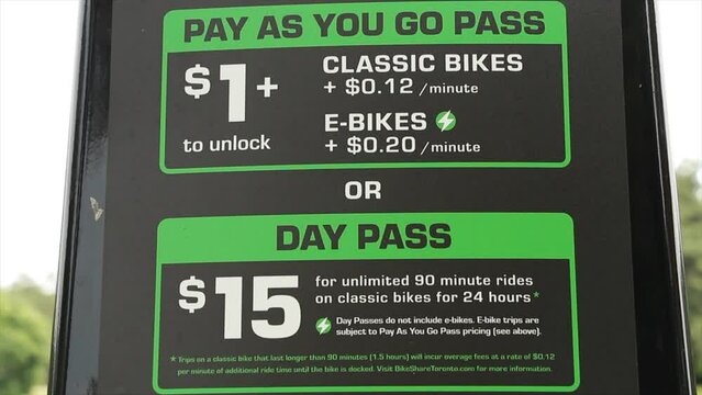 toronto rent a bike or e-bike rates and instructions on pay meter in green and white print on black background, pay as you go or day pass - close shot