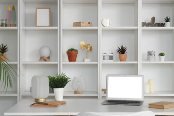 Modern workplace with laptop and shelf unit in office