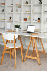 Modern workplace with laptop and shelf unit in office