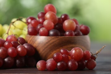 Different fresh ripe grapes on wooden table, closeup