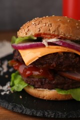 Tasty cheeseburger with patties on wooden table, closeup