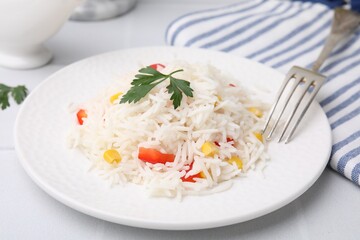 Delicious rice with vegetables and parsley served on table, closeup