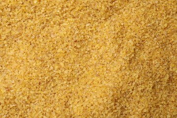 Pile of raw bulgur as background, top view