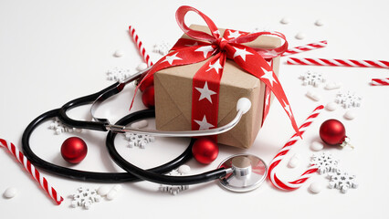 Christmas medical banner.Close-up of stethoscope,gift box,striped lollipops,red balls,stars and...