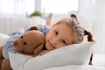 Cute little girl with toy bear in bedroom, closeup