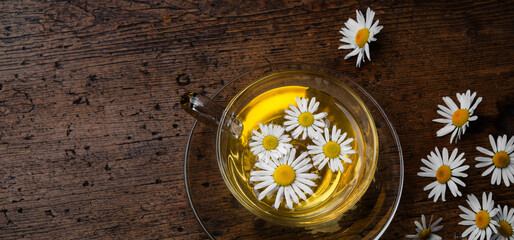 fresh chamomile tea on an old wooden table
