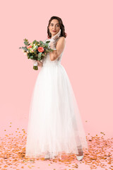 Fototapeta na wymiar Beautiful bride with wedding bouquet on pink background