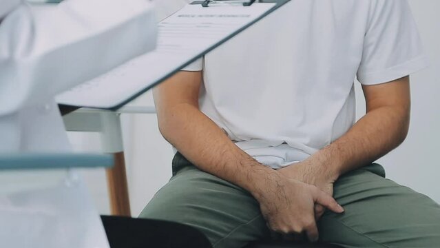 Man with benign prostatic hyperplasia being examined and consulting Asian female doctor and The doctor will ask about the patient's illness and give health advice.