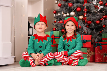 Cute little children in elf costumes at home on Christmas eve