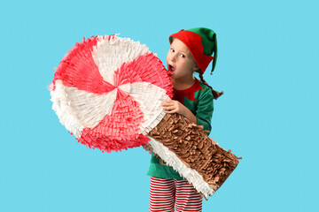 Cute little elf with candy pinata on blue background