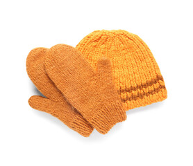 Pair of orange knitted mittens with warm hat on white background