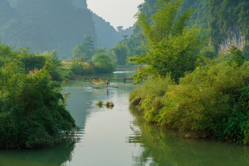 Landscape river scene with stream and a man fishing with net in Trung Khanh, Cao Bang province, Vietnam