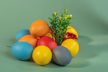 Colorful eggs, symbolizing Easter, on a colorful background and flowers