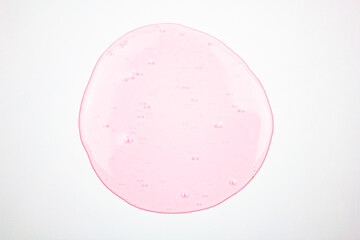 Pink liquid on a white background, transparent pink drop, gel. Concept of cosmetics, science, medicine.