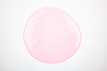 Pink liquid on a white background, transparent pink drop, gel. Concept of cosmetics, science,...