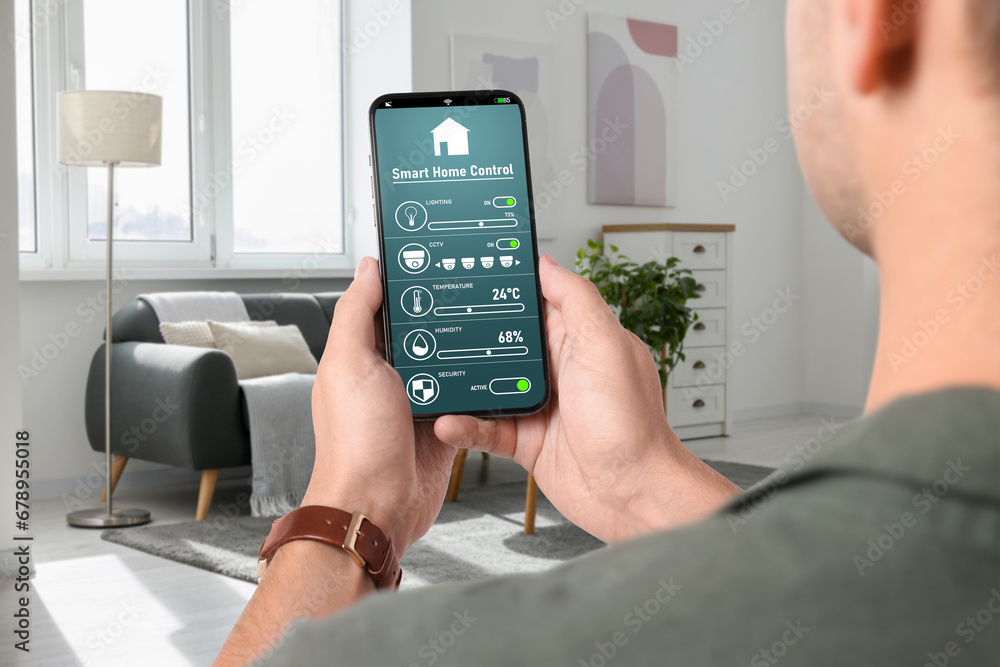 Poster man using smart home control system via application on mobile phone indoors, closeup