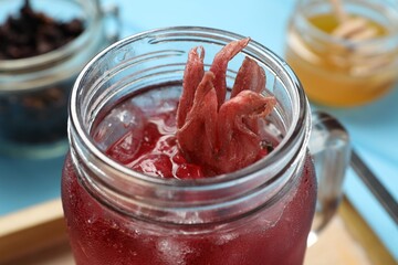 Mason jar of delicious iced hibiscus tea on table, closeup © New Africa