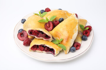 Plate of tasty samosas with berries and mint leaves isolated on white