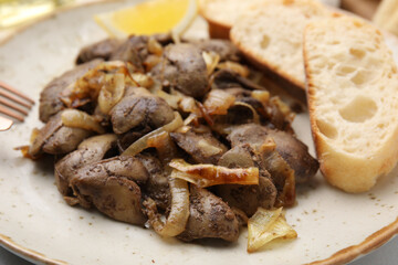Tasty fried chicken liver with onion and bread on white table, closeup