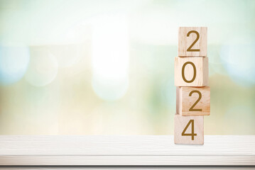 2024 new year greeting card, wooden cubes with 2024 on wood table over blur bokeh background with...