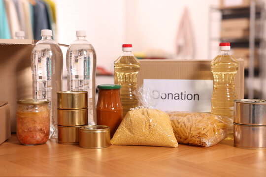 Volunteering. Different food products and cardboard boxes on table in warehouse