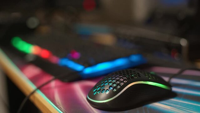 Close up shot of gaming computer mouse and keyboard with multi-colored backlight. Cybersport gaming, gaming addiction