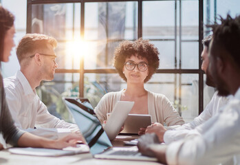 Employees working at computer together, discussing content