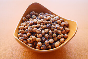  toasted chickpeas in a bowl on orange color background 