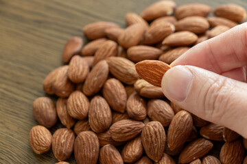 指でアーモンドをつまみ上げる