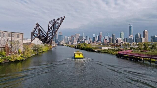 Aerial view following a watertaxi on the south branch of the Chicago river, fall day in USA