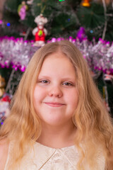 A beautiful elegant girl near the Christmas tree in the New Year. Holiday. New Year. The child is a model.