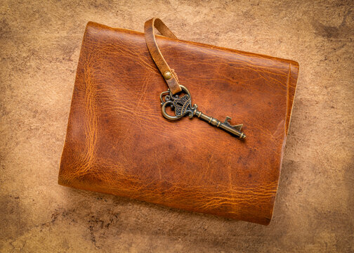 retro leather-bound journal with a decorative key on a handmade bark paper, journaling concept