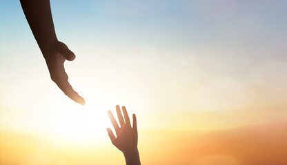 Hand reaching out to help someone on sunset sky background. - obrazy, fototapety, plakaty