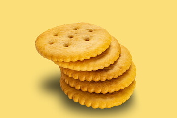 High angle view stack of salted round crackers isolated on yellow background with clipping path.