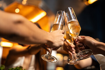 Close-up Group of People Hands Holding Champagne Glass and Cheer Together in Restaurant. They...
