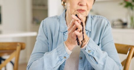 Closeup, old woman or rosary for prayer, faith or religion with guidance, spiritual or peace in a lounge. Apartment, pensioner or elderly person with beads, Christian or worship with Catholic or home