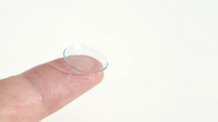 Close up of a hand holding a soft contact lens