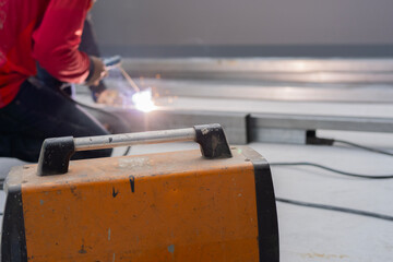 Cropped view of a metallurgy worker is welding with a welding machine in the facility.