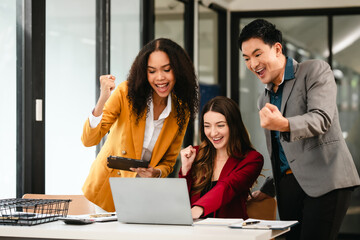 Fototapeta premium Diverse group of three professionals, two women and man, working together on design project around laptop. Product design team for industrial, working together, Asian man, African american people