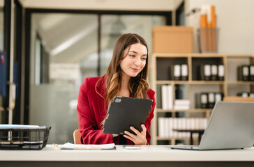Caucasian businesswoman, likely an accountant or CPA, smiling and holding a coffee cup while...