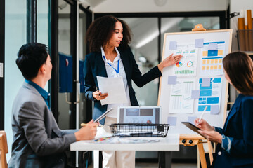 diverse team of professionals engaged in a website graphic design board meeting, sharing opinions on UX and UI design elements. Asian man, African American people, black, afro, caucasian female