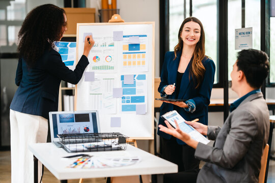 diverse team of professionals engaged in a website graphic design board meeting, sharing opinions on UX and UI design elements. Asian man, African American people, black, afro, caucasian female