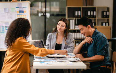 diverse team of professionals engaged in a website graphic design board meeting, sharing opinions on UX and UI design elements. Asian man, African American people, black, afro, caucasian female