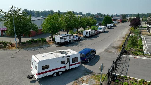 Caravan Trailer Towed Behind A Blue Car At Rest Area In Mission, BC, Canada. - aerial shot