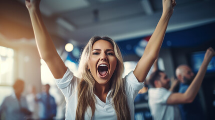 A female sports fan is happy with a group of friends, many cheering together happily and excited to watch their favorite football team. Cheering sports fans wear blue and white cheer team shirts.