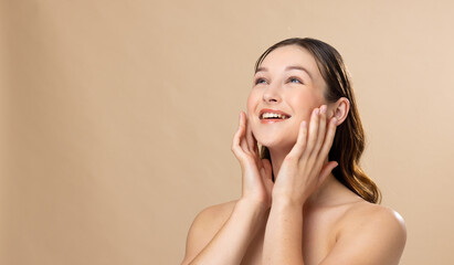 Caucasian woman with brown hair wearing natural makeup on beige background, copy space